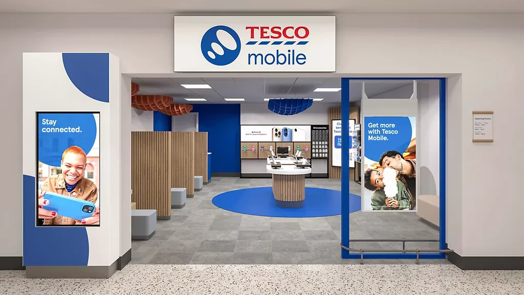 A Tesco Mobile store, with phones on display tables and a welcome screen at the entrance